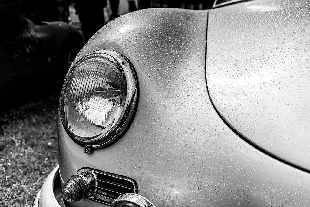 Scheinwerfer eines silbernen Porsche 356 mit Regentropfe